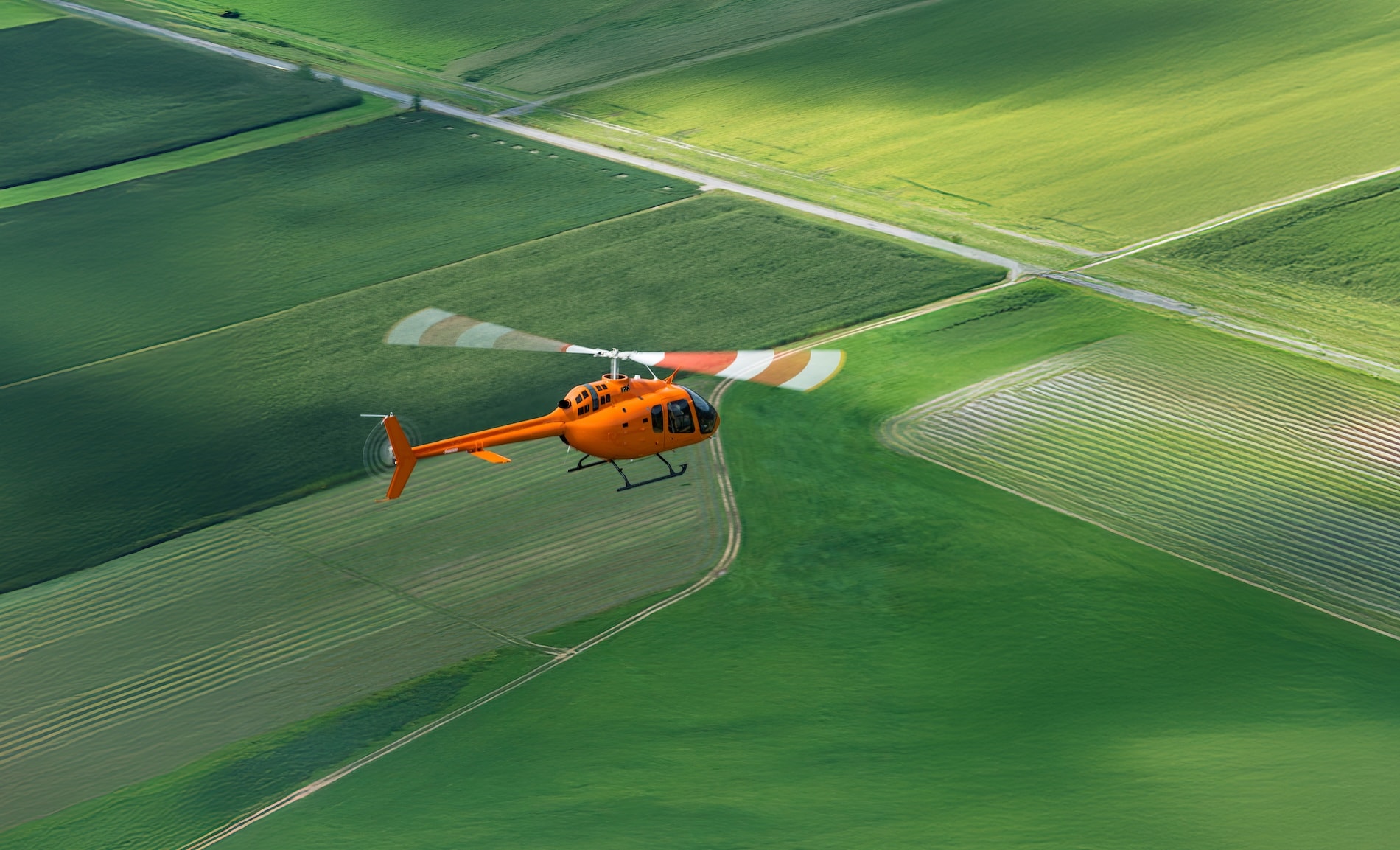 Flugschule Next Bell 505 fliegt über grüne Wiese