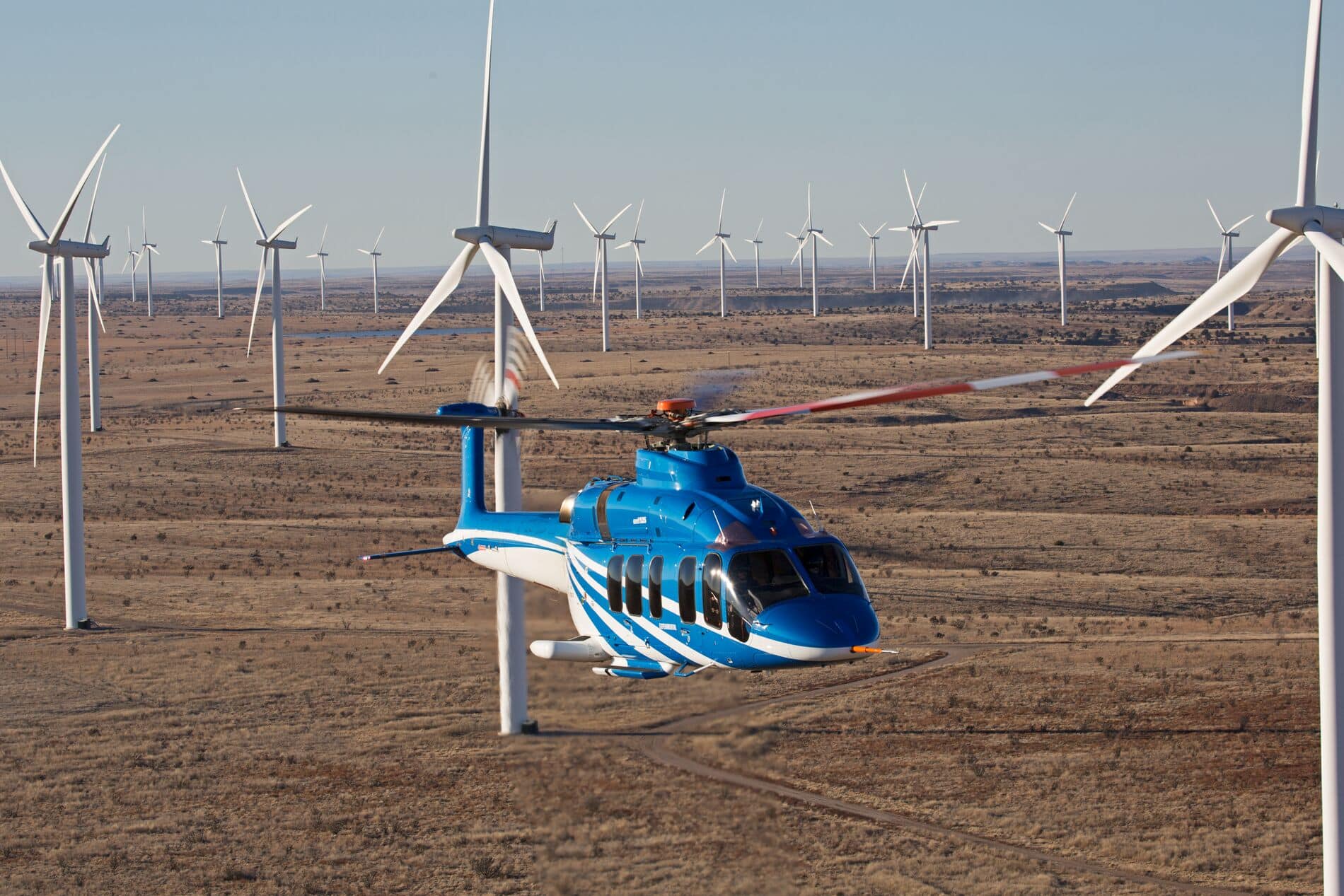 Bell 525 fliegt durch eine Windfarm in der Wüste